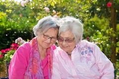 Twee vrolijke hogere vrouwen die in tuin omhelzen royalty-vrije stock fotografie Twee vrolijke hogere vrouwen die in tuin omhelzen royalty-vrije stock fotografie