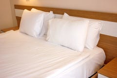 Tweepersoonsbed met witte linens, die op bedtijdslaap wordt voorbereid stock foto Tweepersoonsbed met witte linens, die op bedtijdslaap wordt voorbereid stock foto