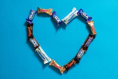 Twix, manière laiteuse, ricanements, générosité, barres de chocolat populaires de sucrerie de Mars mini sur le fond bleu dans la images libres de droits Twix, manière laiteuse, ricanements, générosité, barres de chocolat populaires de sucrerie de Mars mini sur le fond bleu dans la images libres de droits
