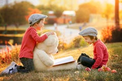 Two adorable little boys with his teddy bear friend in the park Royalty Free Stock Photography Two adorable little boys with his teddy bear friend in the park Royalty Free Stock Photography
