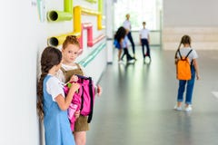 two adorable schoolgirls chatting at school corridor stock photos two adorable schoolgirls chatting at school corridor stock photos