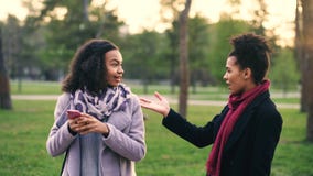 Two attractive mixed race women surpisely have meeting in the park near mall store stock images Two attractive mixed race women surpisely have meeting in the park near mall store stock images