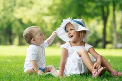 Two Babies Are Sitting On The Grass Stock Photo