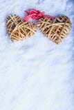 Two beautiful vintage entwined beige flaxen hearts tied together with a ribbon on white snow. Love and St. Valentines Day concept stock photography Two beautiful vintage entwined beige flaxen hearts tied together with a ribbon on white snow. Love and St. Valentines Day concept stock photography