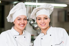 A two beautifull young female chef posing for camera Royalty Free Stock Photos A two beautifull young female chef posing for camera Royalty Free Stock Photos