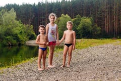 Two Boys And A Girl On The Banks Of The River In Summer Royalty Free Stock Photography