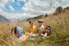 Two boys have got picnic in mountain field Stock Photos Two boys have got picnic in mountain field Stock Photos
