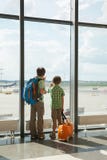 Two boys are looking at flying field in airport terminal Royalty Free Stock Photography Two boys are looking at flying field in airport terminal Royalty Free Stock Photography