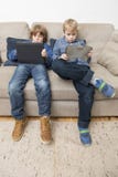 Two boys playing video games on a tablet computer Stock Image Two boys playing video games on a tablet computer Stock Image