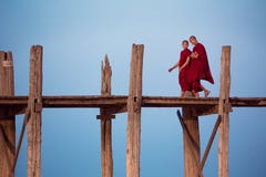 Two buddhist monks talk while walking along U-Bein bridge royalty free stock images Two buddhist monks talk while walking along U-Bein bridge royalty free stock images