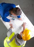 Two builders discuss construction blueprints