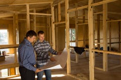 Two Builders Discussing The Interior Of A House Stock Photos