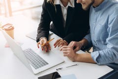 Two business people working on laptop computer with business document, graph diagram and calculator on office table royalty free stock photo Two business people working on laptop computer with business document, graph diagram and calculator on office table royalty free stock photo