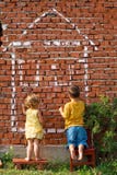 Two children drawing a house