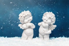 Two Christmas baby angels statuettes on snow at Christmas royalty free stock images Two Christmas baby angels statuettes on snow at Christmas royalty free stock images
