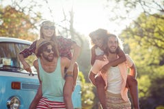 Two couples having piggy ride in park Stock Image Two couples having piggy ride in park Stock Image