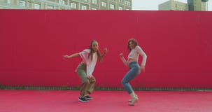 Two dancing mixed race girls perform passionate contemporary expressive dance outside. Female dancers cool moving