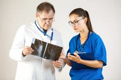 Two doctors look at an x-ray of the hand and discuss the problem stock photography Two doctors look at an x-ray of the hand and discuss the problem stock photography