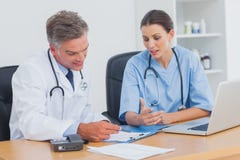 Two doctors working on an important folder Royalty Free Stock Photography Two doctors working on an important folder Royalty Free Stock Photography