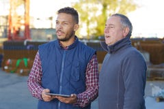 Two engineer discussing new project with large industry background royalty free stock photo Two engineer discussing new project with large industry background royalty free stock photo