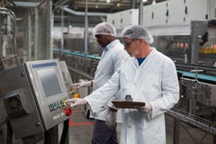 Two Factory Engineers Operating Machine In Factory Royalty Free Stock Image Two Factory Engineers Operating Machine In Factory Royalty Free Stock Image