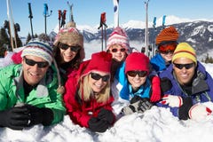 Two Family Having Fun On Ski Holiday In Mountains