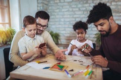 Two fathers play educational games with their children stock photo Two fathers play educational games with their children stock photo