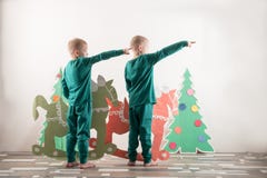 Two funny boys in a Santa Claus hat are playing with horses drawn on cardboard. The guys have fun at home. Christmas holiday conce Royalty Free Stock Photo Two funny boys in a Santa Claus hat are playing with horses drawn on cardboard. The guys have fun at home. Christmas holiday conce Royalty Free Stock Photo