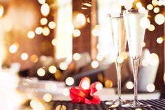 Two glasses of champagne with red flower in a spa lounge. Spa time concept. Spa lounge area. . Bold festive bokeh stock images Two glasses of champagne with red flower in a spa lounge. Spa time concept. Spa lounge area. . Bold festive bokeh stock images