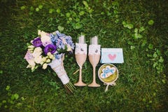 Two glasses with flowers, bottle of champagne and wedding rings on the grass. Wedding accessories royalty free stock image Two glasses with flowers, bottle of champagne and wedding rings on the grass. Wedding accessories royalty free stock image