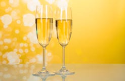 Two Glasses Of Champagne With Bubbles On Bright Yellow Stock Photography