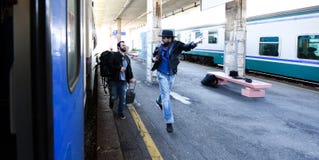 Two guys are late for the train and running to catch it. One of them is wasted. royalty free stock photography Two guys are late for the train and running to catch it. One of them is wasted. royalty free stock photography