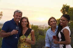 Two happy adult couples socialising outdoors look to camera stock image Two happy adult couples socialising outdoors look to camera stock image