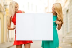 Two happy blonde women with blank white board royalty free stock image Two happy blonde women with blank white board royalty free stock image