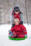 Two happy boys riding at the slide on snowy park stock photography Two happy boys riding at the slide on snowy park stock photography