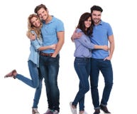Two happy couples of young casual people standing embraced