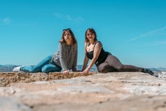Women embrace and laugh while sitting on the castle stone stock image Women embrace and laugh while sitting on the castle stone stock image