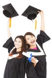 Two happy young graduate students holding hats and diploma stock photography Two happy young graduate students holding hats and diploma stock photography