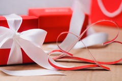 Two homemade paper red hearts and red gift boxes tied with white ribbons. Valentine`s day and love symbol stock photography Two homemade paper red hearts and red gift boxes tied with white ribbons. Valentine`s day and love symbol stock photography