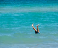 Two legs sticking up out of beautiful blue calm ocean stock image Two legs sticking up out of beautiful blue calm ocean stock image