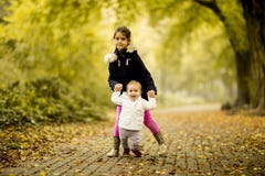 Two little girl sisters in the autumn park stock photos Two little girl sisters in the autumn park stock photos