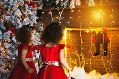 Two curly little girls looking at the christmas fireplace near b stock photos Two curly little girls looking at the christmas fireplace near b stock photos