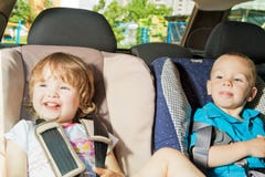 Two little kids on back seat in child safety seat