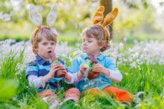 Two little kids playing with Easter chocolate bunny Stock Photos Two little kids playing with Easter chocolate bunny Stock Photos
