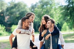 Two loving couples piggyback having fun outdoors Royalty Free Stock Photography Two loving couples piggyback having fun outdoors Royalty Free Stock Photography