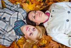 Two Lying Girls In Leaves Royalty Free Stock Photos