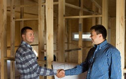 Two Men Shaking Hands In A Half Constructed House Stock Images