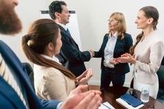 Two middle-aged business associates smiling while shaking hands stock photos Two middle-aged business associates smiling while shaking hands stock photos