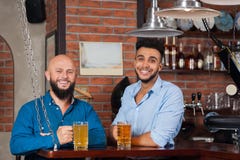 Two Mix Race Man In Bar Hold Glasses Sit At Counter, Drinking Beer, Cheerful Friends Meeting stock images Two Mix Race Man In Bar Hold Glasses Sit At Counter, Drinking Beer, Cheerful Friends Meeting stock images