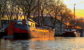 Two old wooden ship in sunset light in the river canal by the sh stock images Two old wooden ship in sunset light in the river canal by the sh stock images